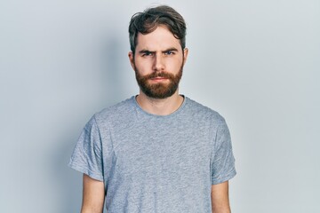 Obraz premium Caucasian man with beard wearing casual grey t shirt skeptic and nervous, frowning upset because of problem. negative person.