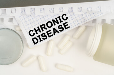 On the table is an open jar of pills and a sheet of paper with the inscription - Chronic Disease