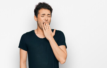 Fototapeta na wymiar Young handsome man wearing casual black t shirt bored yawning tired covering mouth with hand. restless and sleepiness.