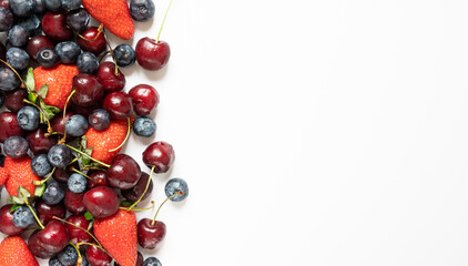 lots of strawberries, cherries and blueberries. juicy summer on white background with copy space