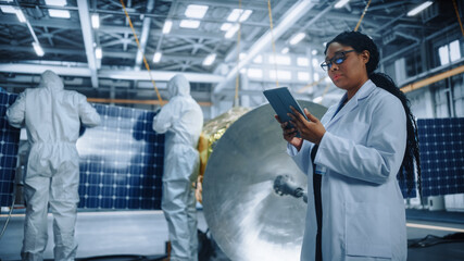 Technicians in Protective Suits Working on Satellite Construction, under Chief Engineer Control. Aerospace Agency: Team of Scientists Fixing Solar Panel Wings to Spacecraft. Space Exploration Mission