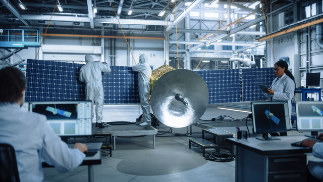 Team of Engineers Working on Satellite Construction. Aerospace Agency: Diverse Group of Scientists Developing Spacecraft for Space Exploration, Navigation, Wireless Communications, Cosmos Observation 