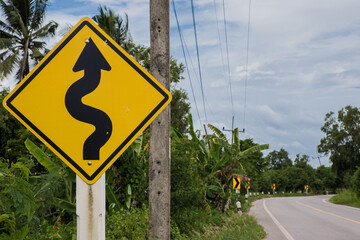 Road sign curved reminds the motorists and vehicles while driving with yellow sign reflecting light...