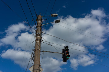 Concrete pole with attached traffic light, night lights, electric and telephone cables, fiber optic...