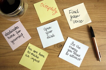 Inspirational and motivational slogans handwritten on sticky notes with pen and coffee