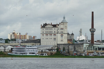 Obraz premium View over the branch of the Rio Negro river, the Iguarapé de Sao Raimundo to the historic old town with an abandoned former brewery building (Cervejeria). Manaus, Amazonas state, Brazil.