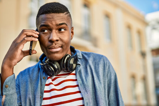 Young african american man with serious expression talking on the smartphone at the city.
