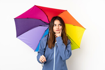 Woman holding an umbrella isolated on white background thinking an idea