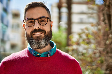 Young hispanic executive man smiling happy standing at the city.