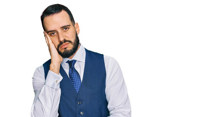 Young man with beard wearing business vest thinking looking tired and bored with depression problems with crossed arms.