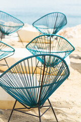 Blue round chairs on the rocks by the sea, vacation concept.