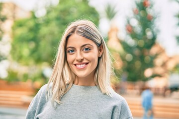 Young blonde girl smiling happy standing at the park.