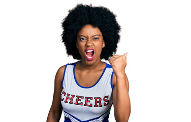 Young african american woman wearing cheerleader uniform angry and mad raising fist frustrated and furious while shouting with anger. rage and aggressive concept.