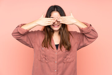 Young caucasian woman isolated on pink background covering eyes by hands