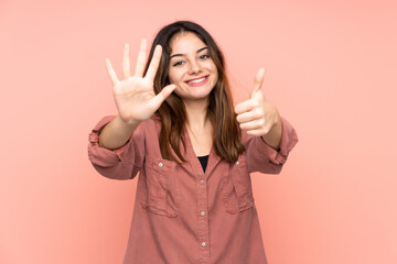 Young caucasian woman isolated on pink background counting six with fingers