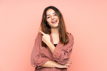 Obraz premium Young caucasian woman isolated on pink background surprised and pointing side