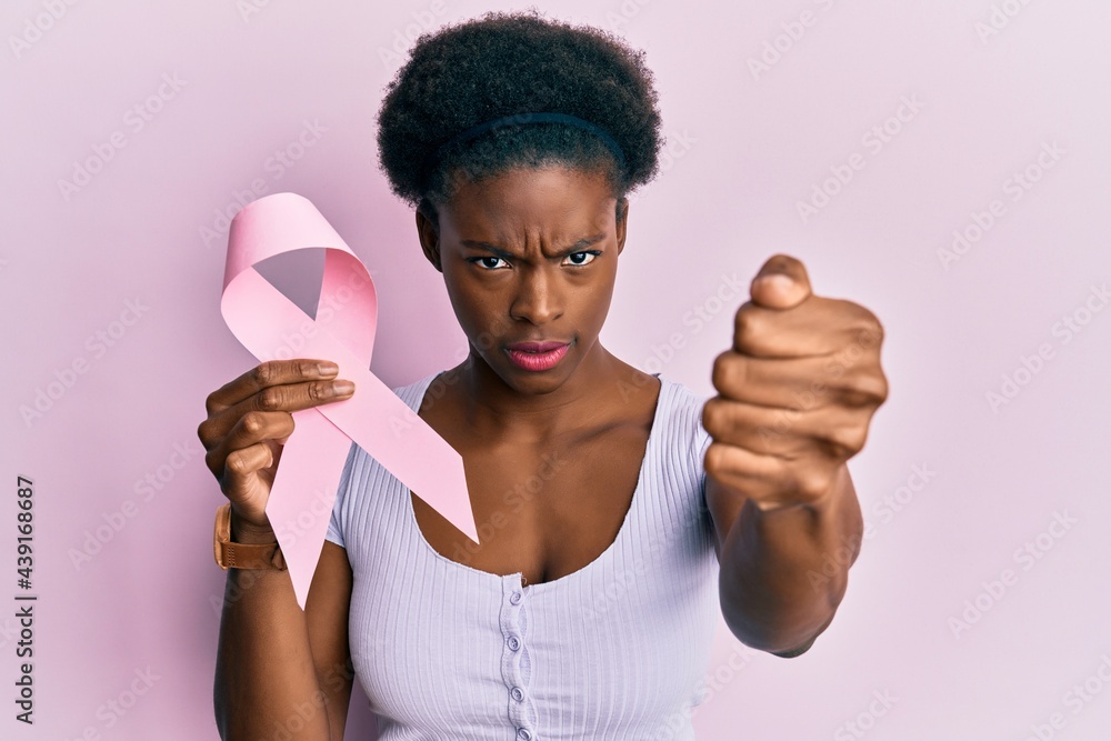 Poster Young african american girl holding pink cancer ribbon annoyed and frustrated shouting with anger, yelling crazy with anger and hand raised