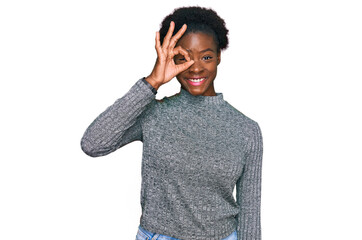 Young african american girl wearing casual clothes doing ok gesture with hand smiling, eye looking through fingers with happy face.