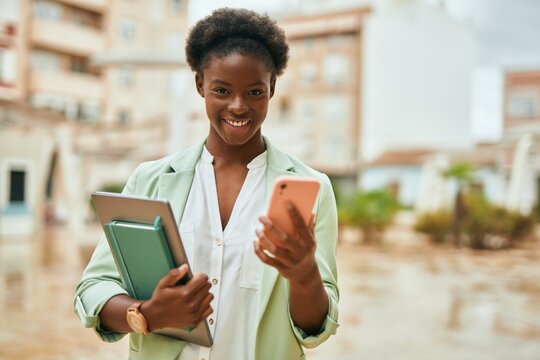 Young african american businesswoman smiling happy using smartphone at the city.