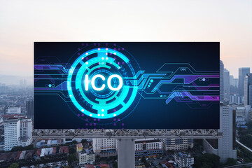 ICO hologram icon on billboard over panorama city view of Kuala Lumpur at sunset. KL is the hub of...