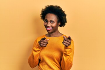 Fototapeta na wymiar Young african american woman wearing casual clothes pointing fingers to camera with happy and funny face. good energy and vibes.