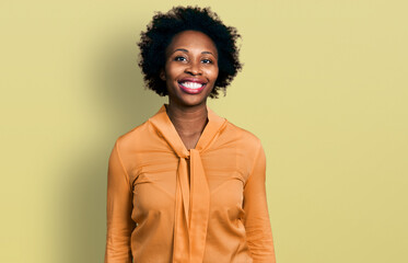 Fototapeta na wymiar African american woman with afro hair wearing elegant shirt looking positive and happy standing and smiling with a confident smile showing teeth