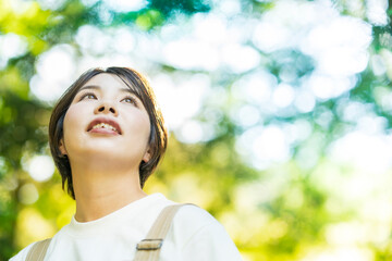 Fototapeta premium 森の木々を見上げる女性