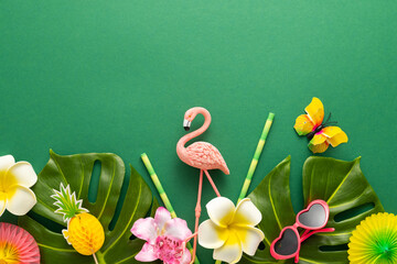 Exotic tropical summer background. Summer beach party concept. Pink flamingo, tropical leaves, orchid flowers and other accessories on green background. Flat lay, copy space.