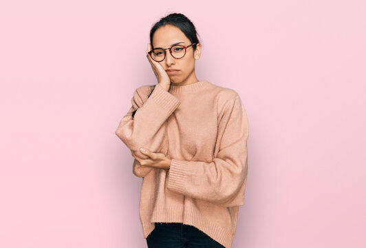 Young hispanic girl wearing casual clothes and glasses thinking looking tired and bored with depression problems with crossed arms.
