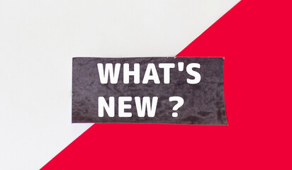 What's new, text on black sticker and red and white background.