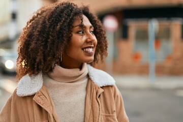Young african american woman smiling happy standing at the city.
