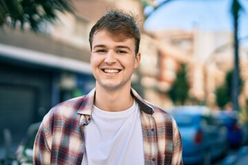 Fototapeta premium Young caucasian man smiling happy standing at the city.