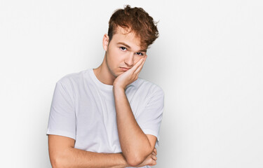 Young caucasian man wearing casual white t shirt thinking looking tired and bored with depression problems with crossed arms.