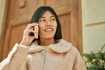 Young asian woman smiling happy talking on the smartphone at the city.