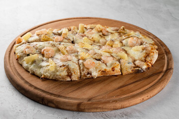 Pinsa romana with shrimps and pineapple on wooden plate on white background. Seafood scrocchiarella.