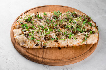 Italian pinsa romana with french escargot grape snails on white background. Pinsa with snail, cheese, microgreen. Italian gourmet cuisine