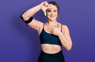 Fototapeta na wymiar Young hispanic woman wearing sportswear smiling making frame with hands and fingers with happy face. creativity and photography concept.
