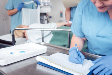 Nurse writing pre surgery report on file