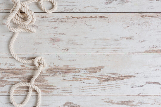 Sea background with marine rope on white wooden deck top view.