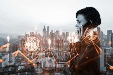 Attractive black woman new approaches to protect clients confidential information using phone. IT social network icons over Kuala Lumpur city background.