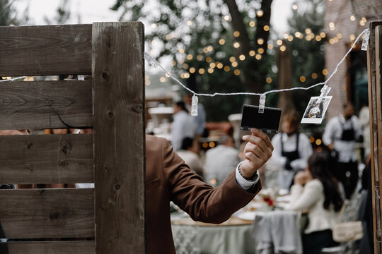 the groom hangs a palaroid snapshot on the board