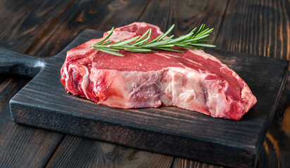 Raw T-bone steak with fresh rosemary