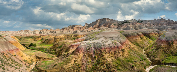 Title: Yellow mounds and colorful red rocks and dramatic mountains in the Badlands National Park -...