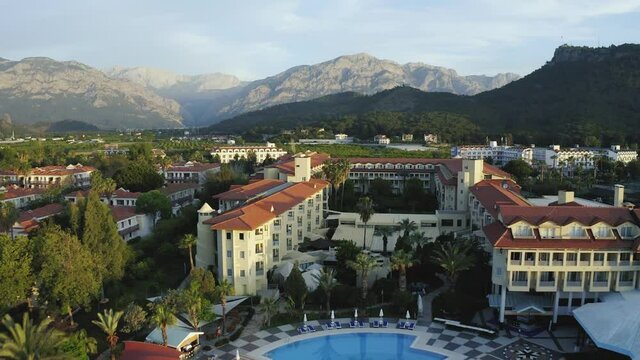 Panoramic view of resort hotel with mountains in the background. Aerial view of beautiful hotel with swimming pool in Kiris, Kemer, Turkey