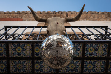 Balcony decorated with a bull skull and a disco ball in the streets of the old town of Javea, Alicante, Spain