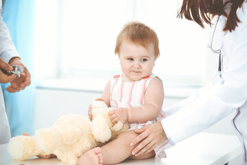 Fototapeta premium Happy girl-child at usual medical inspection. Doctor and female toddler patient in the clinic. Healthcare concept