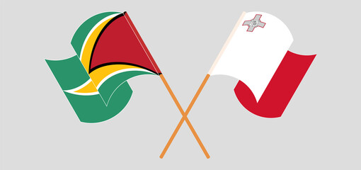 Crossed and waving flags of Guyana and Malta