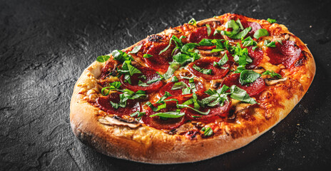 flatbread Pepperoni Pizza with Mozzarella cheese, salami, Tomato sauce, pepper, Spices. Italian pizza on Dark grey black slate background