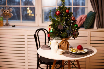 Christmas tree on the table in the room decorated for New year