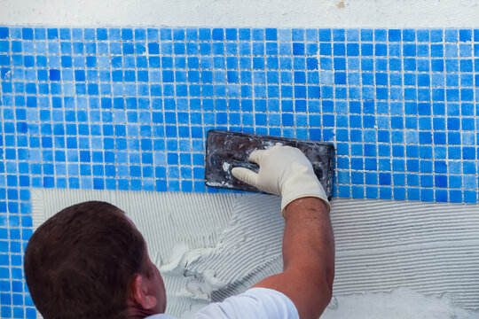Laying tile in the pool. Pool repairing work.